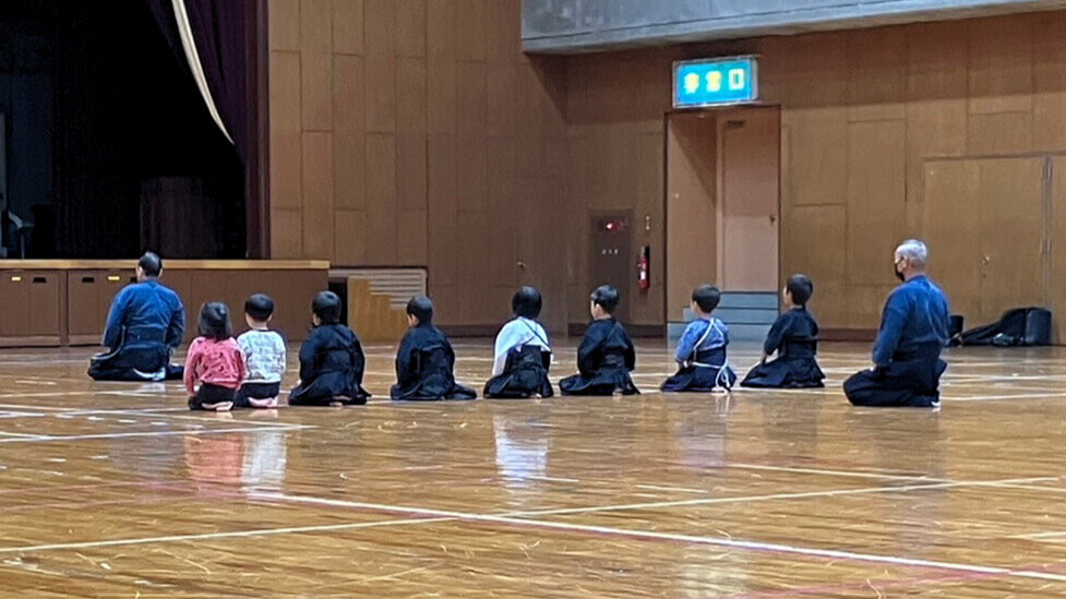 先輩が後輩の面ひもを整えている様子