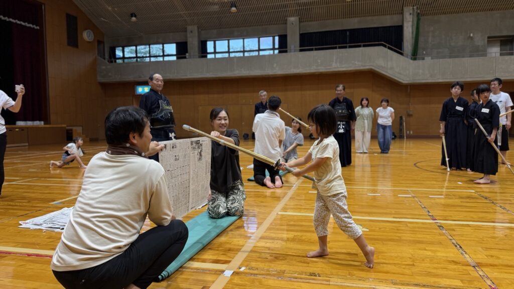 新聞紙に向かって竹刀を振り下ろす子ども