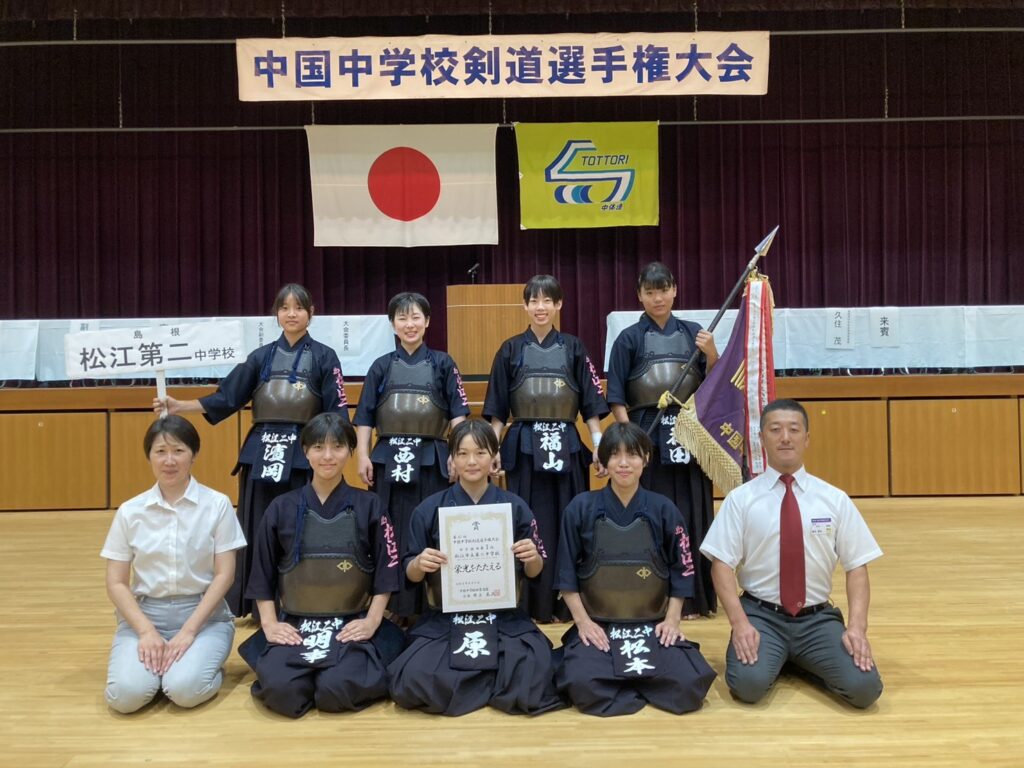 優勝旗と賞状を持って記念撮影する松江市立第二中学校の女子選手たち