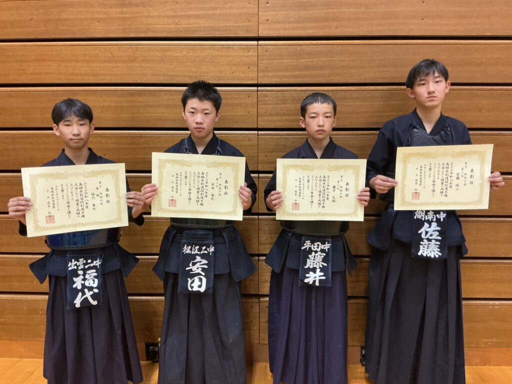 男子初段の部の入賞者4名が賞状を持って並ぶ