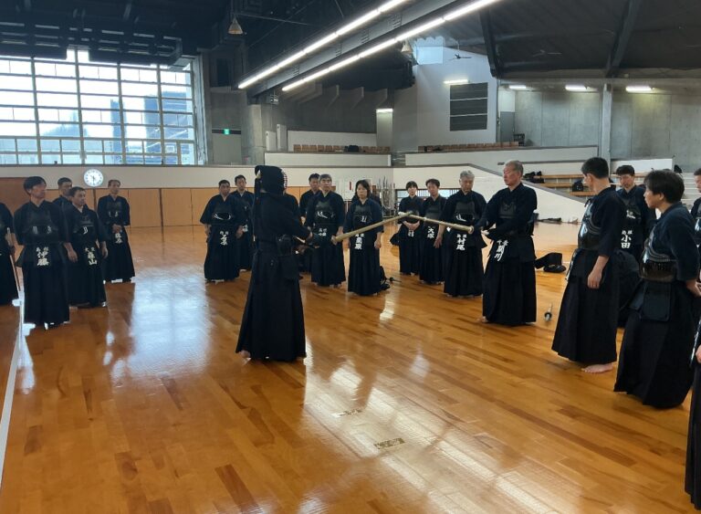 面を着けた講師に向かって構える受講者