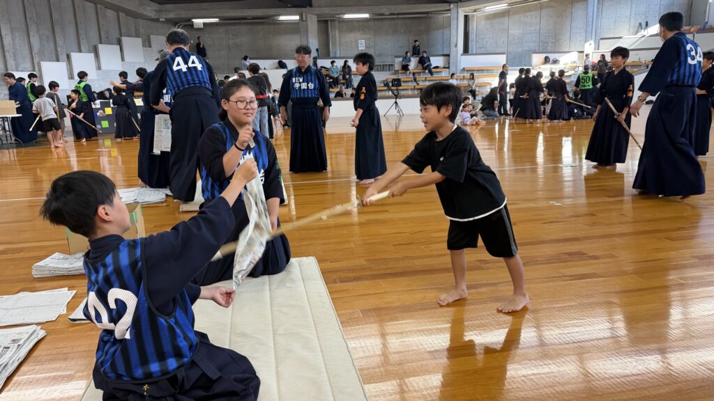 竹刀で新聞を切る子ども