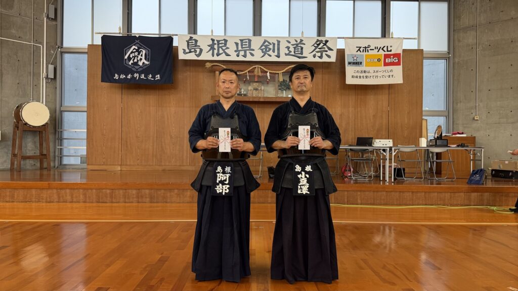 優秀試合の大将2名がのし袋を持って並ぶ